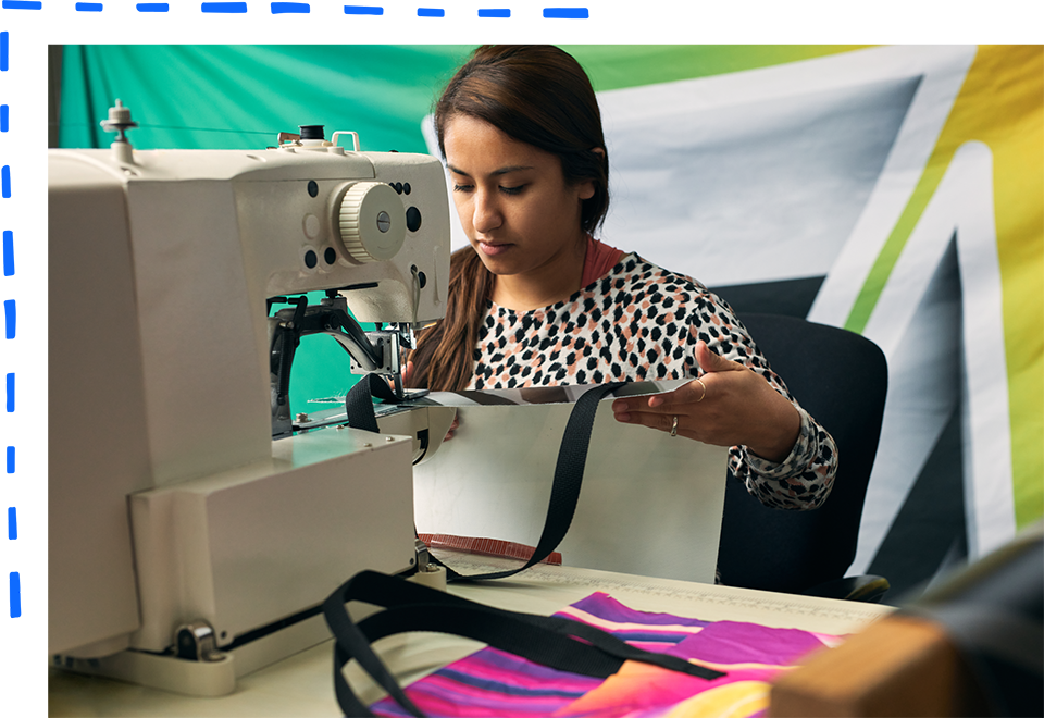 MHW employee using a sewing machine to make a vinyl bag